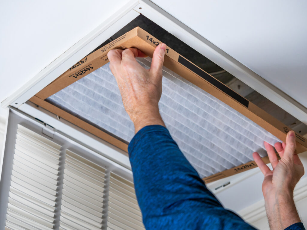 HVAC technician replacing a home air filter in Stevenson Ranch