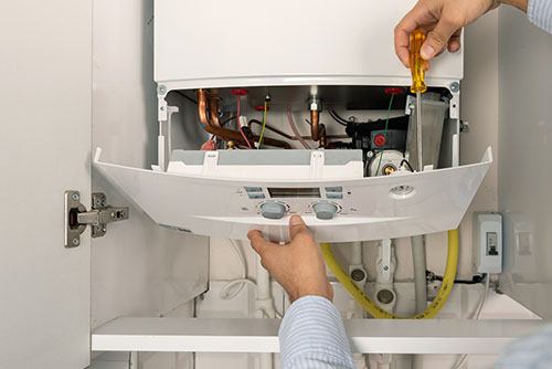 Heating technician repairing a residential boiler in Stevenson Ranch