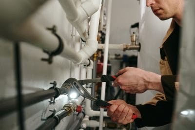 Technician inspecting commercial plumbing pipes in Stevenson Ranch
