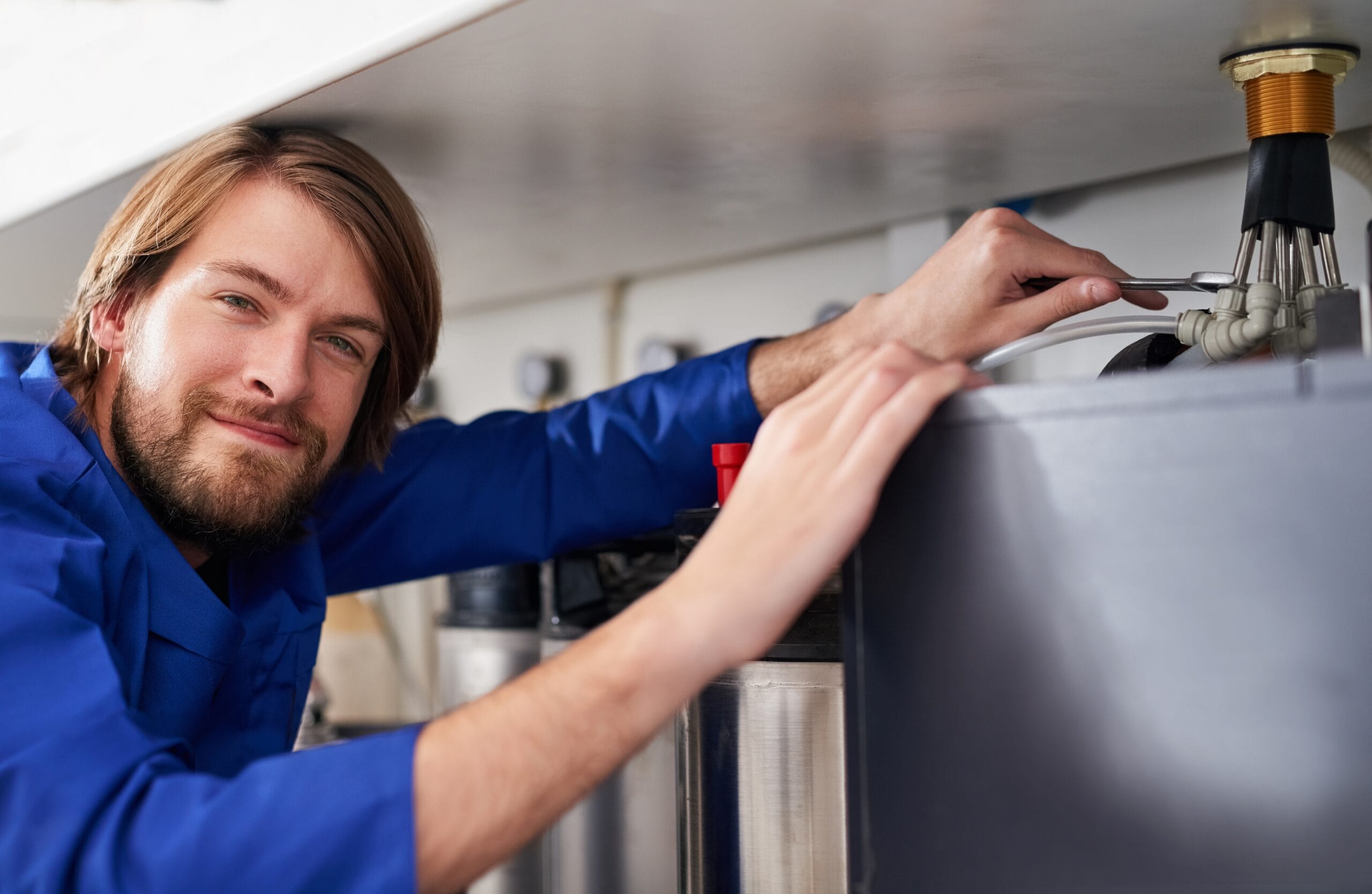 Technician servicing a residential water heater tank in Stevenson Ranch