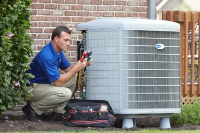 HVAC technician inspecting an outdoor AC unit in Stevenson Ranch